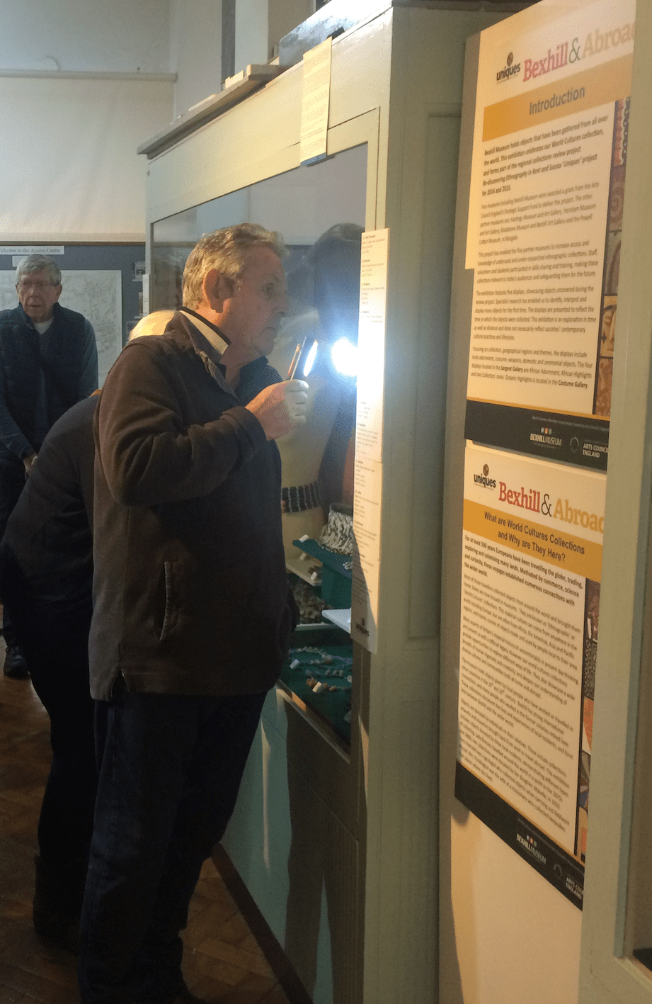 Paul Murray using a LED torch to study a gallery display